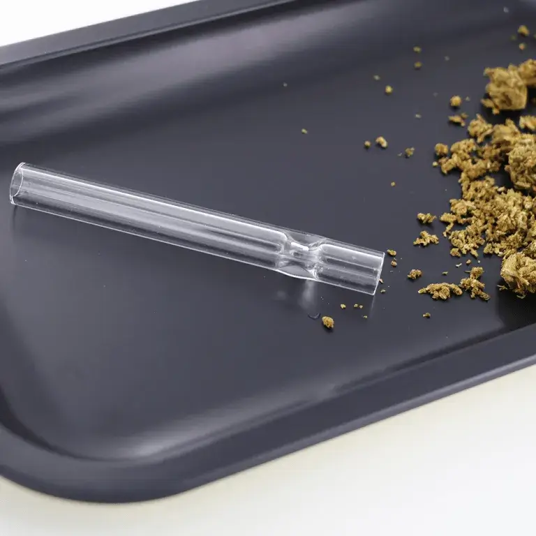 glass chillum with herb on a tray